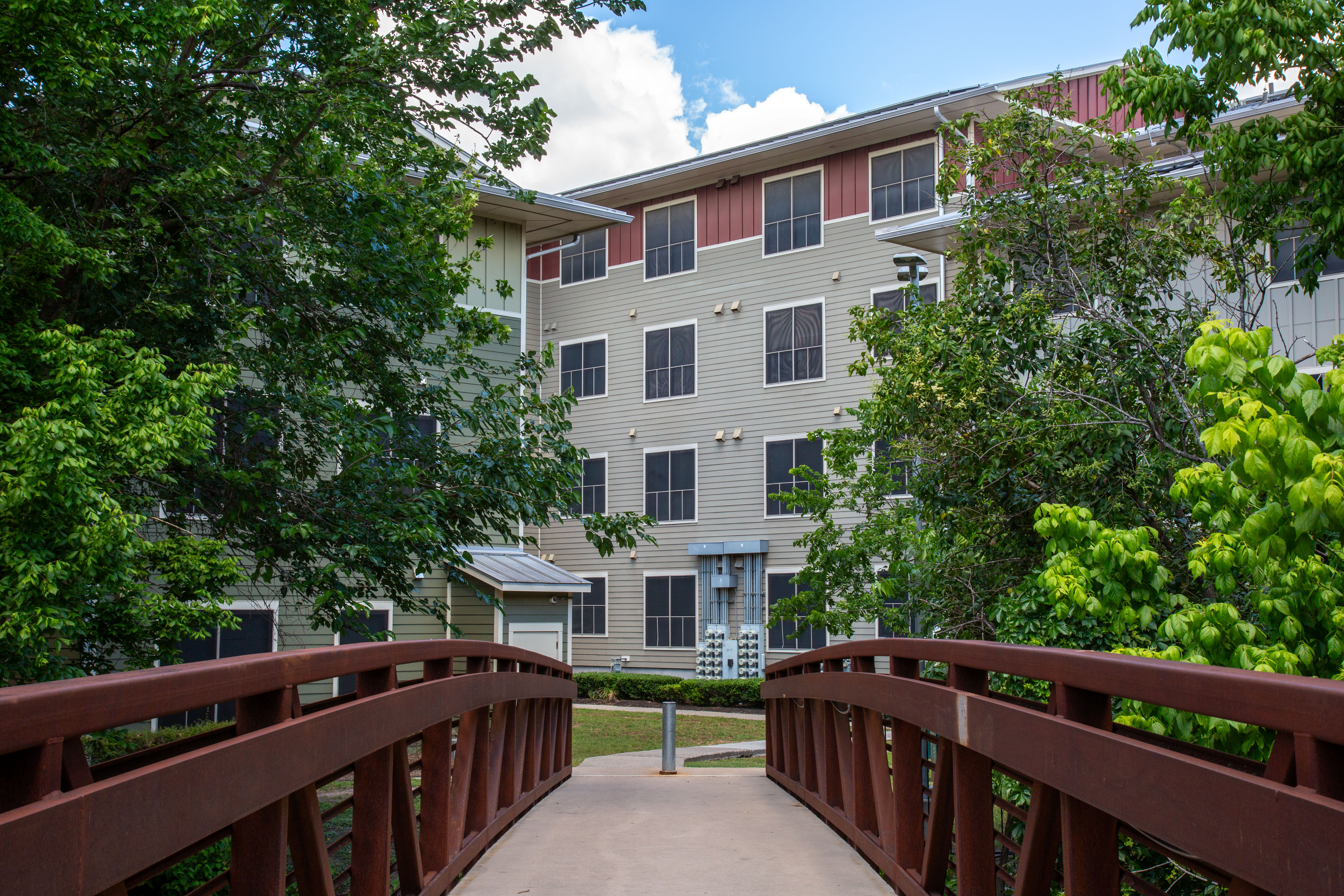 Community with wooden bridge and view to building exterior at M Station in Austin, Texas, 