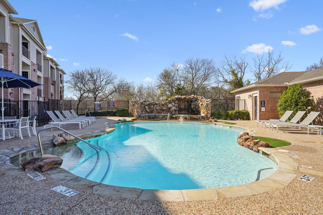 Sparkling swimming pool with sun deck, lounge chairs and access to clubhouse at Mission Eagle Pointe in Allen, Texas, 