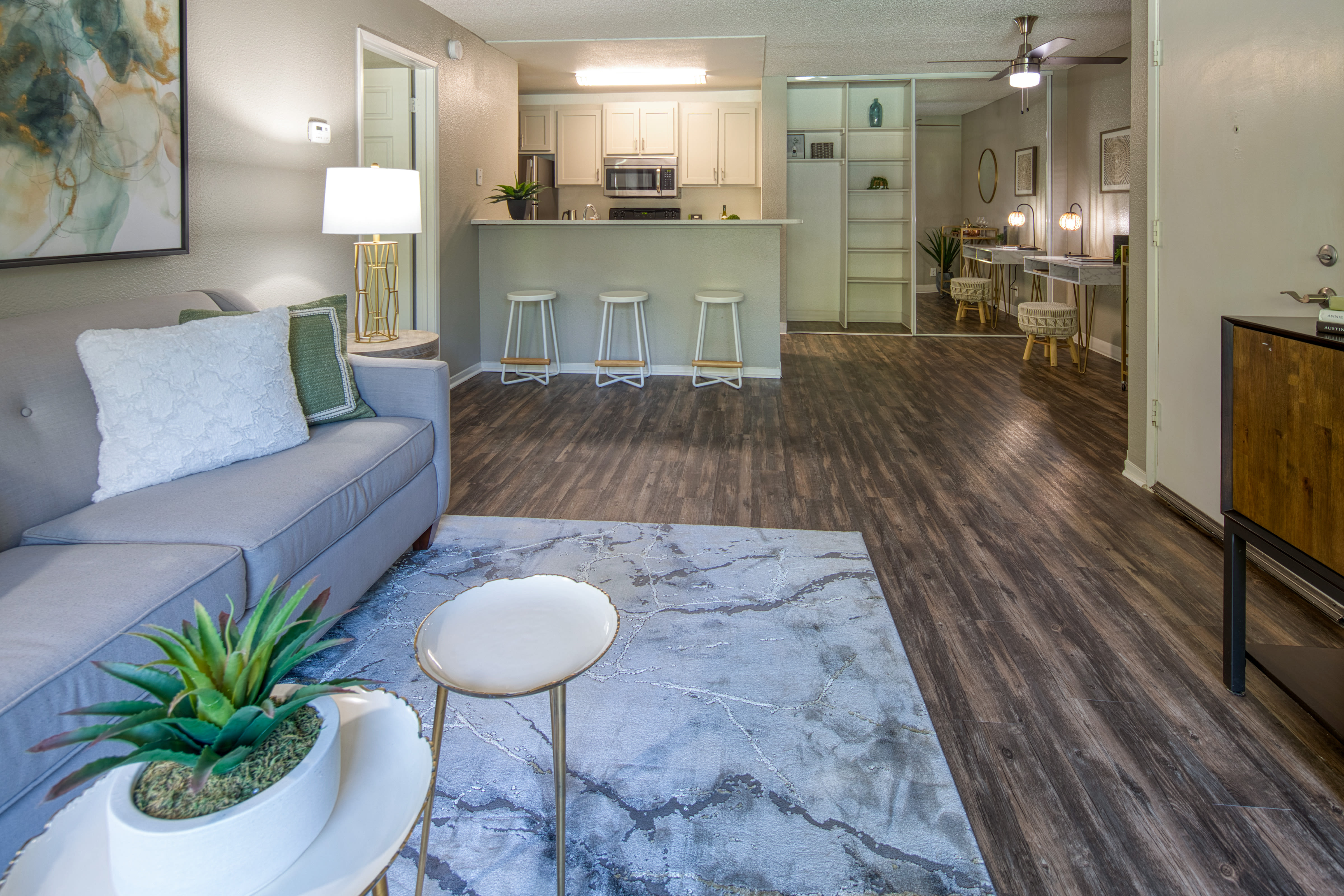 Living room with wood-style flooring at Falls at Arden in Sacramento, California