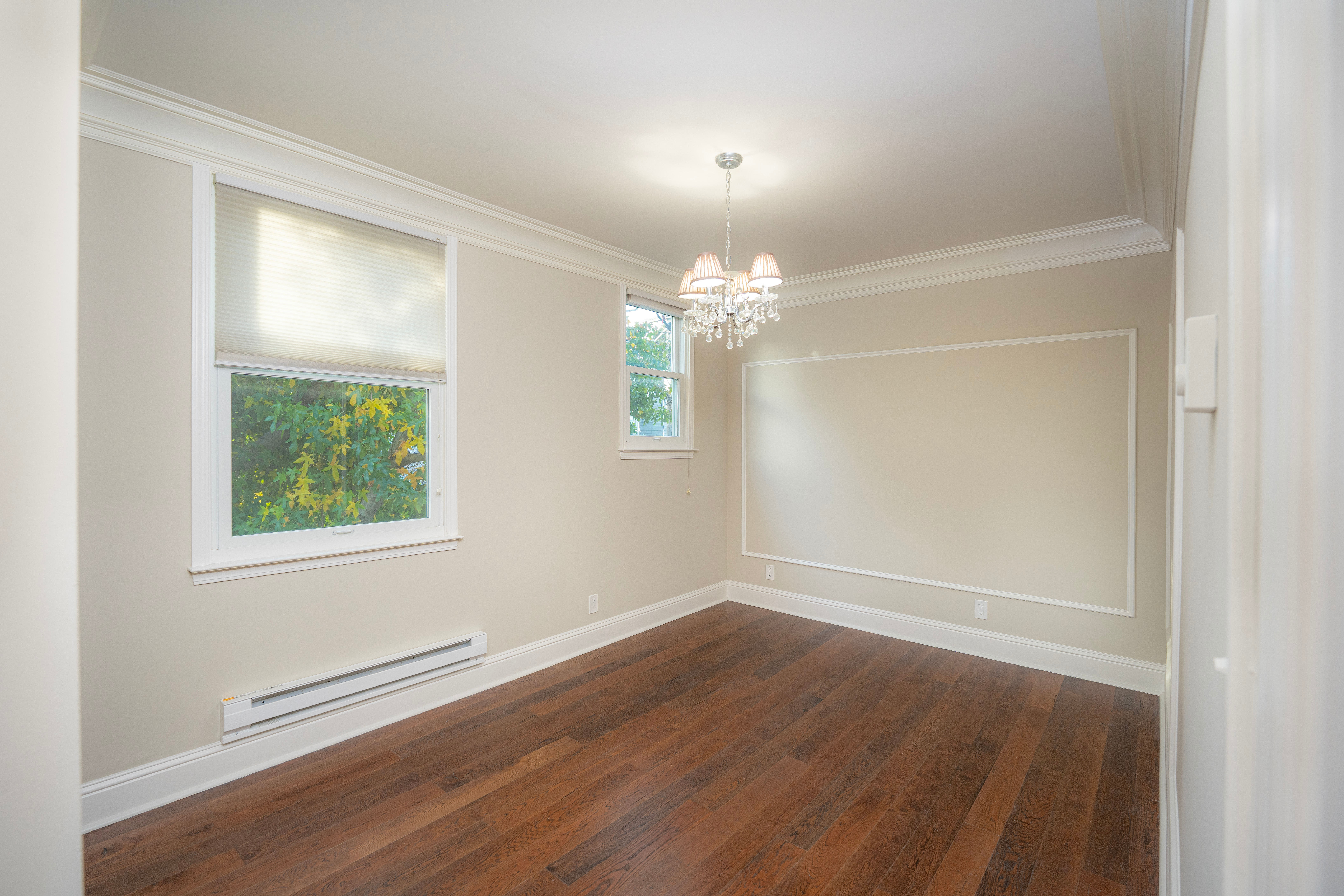 Empty room with chandelier and wooden floor