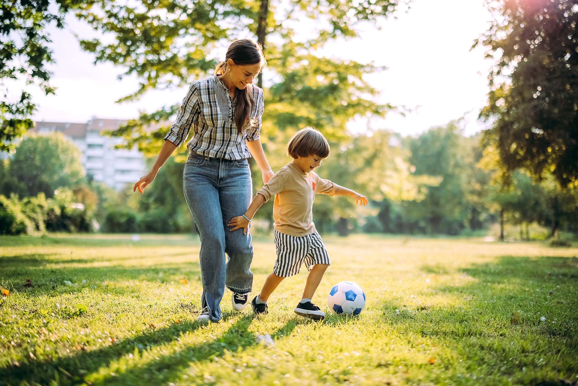 Resident woman playing soccer with her child near Vineyards in Katy, Texas