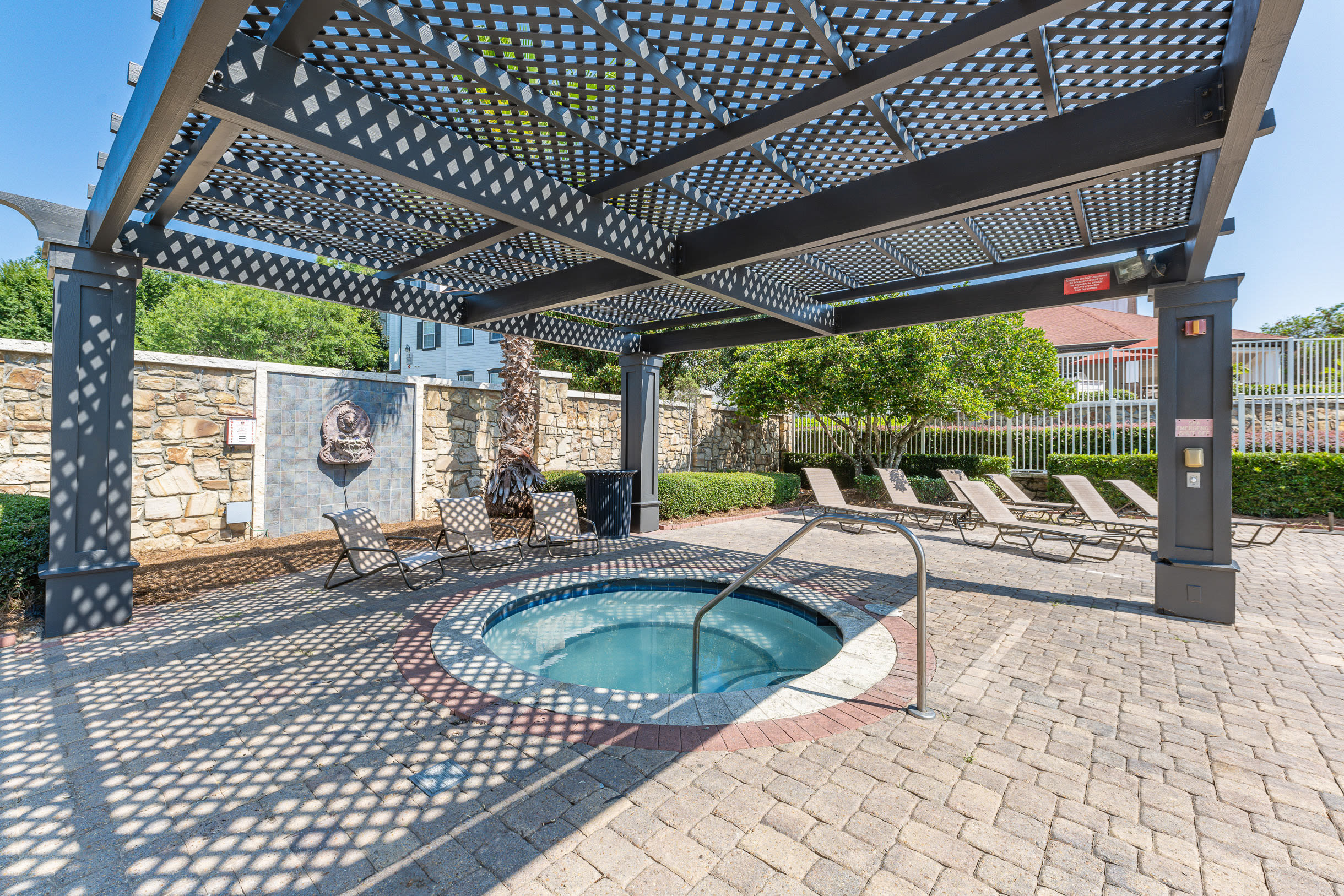 Outdoor lounge area with circular pool and pergola at Century Capital City in Tallahassee, Florida