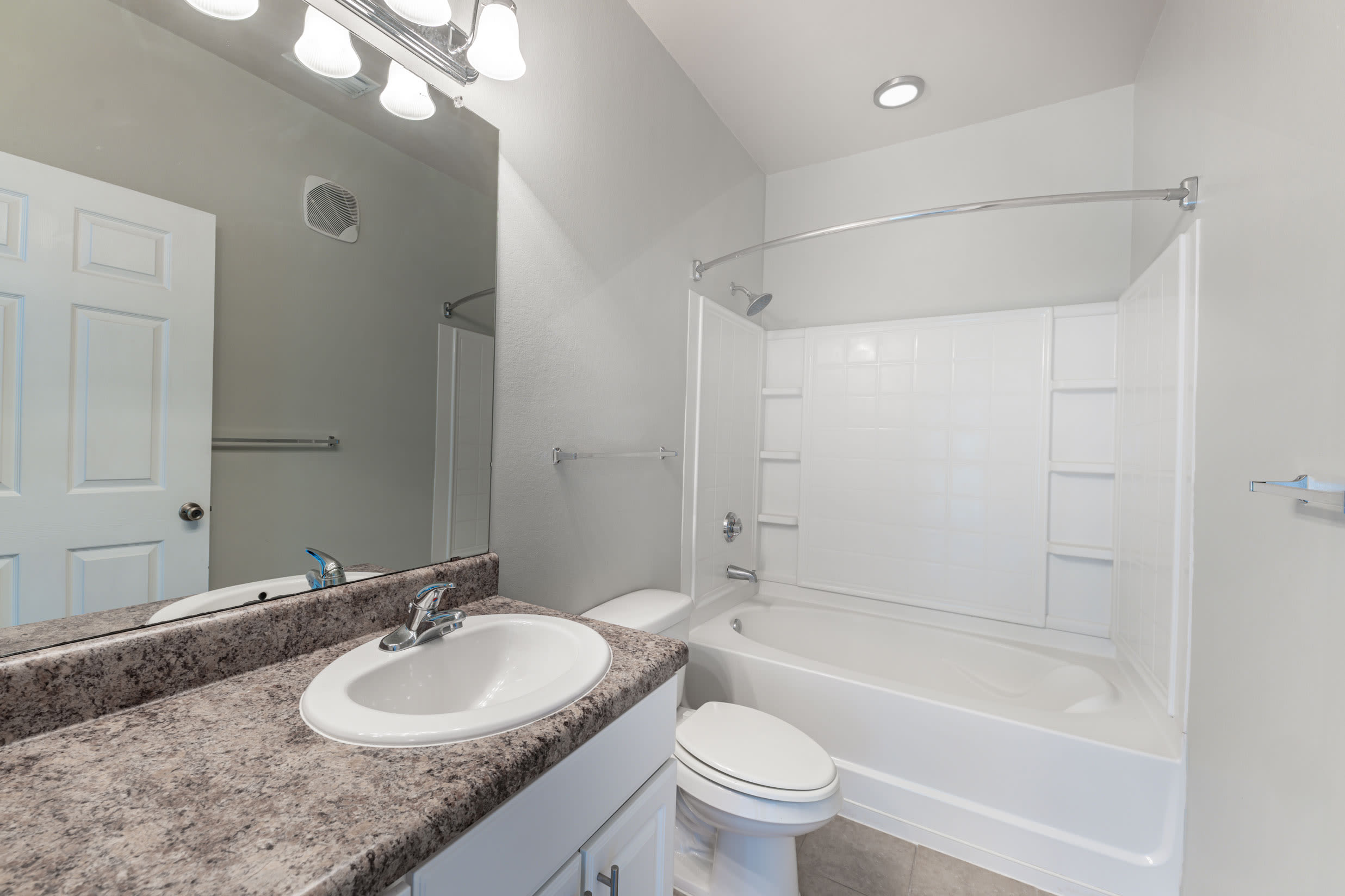 Bathroom with bathtub and a large mirror at Century Capital City in Tallahassee, Florida