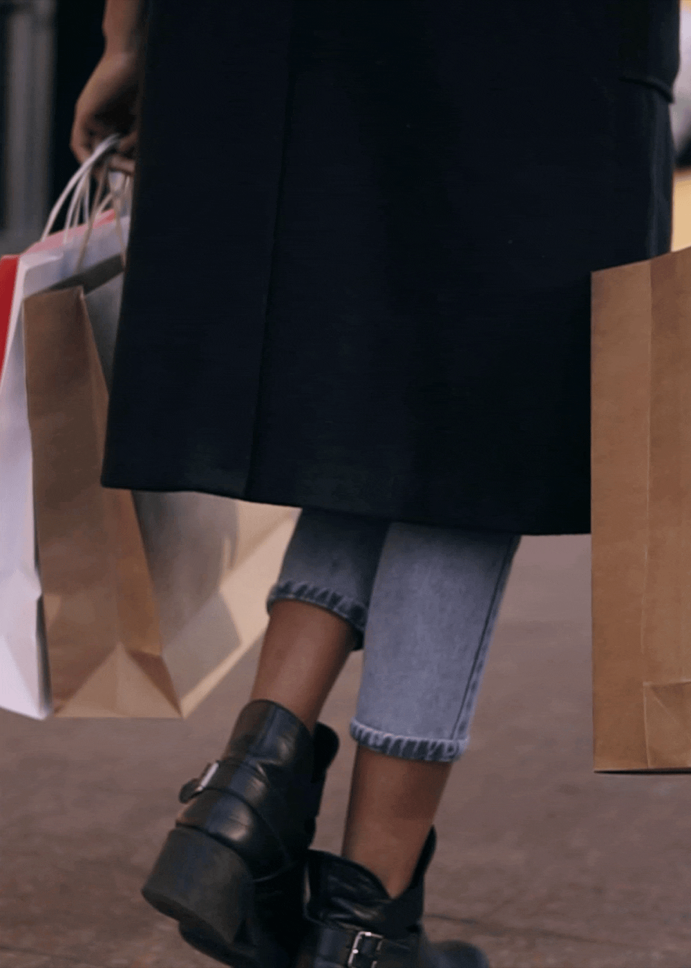 Woman walking on the street carrying shopping bags at The Indie Glendale Collection in Glendale, California