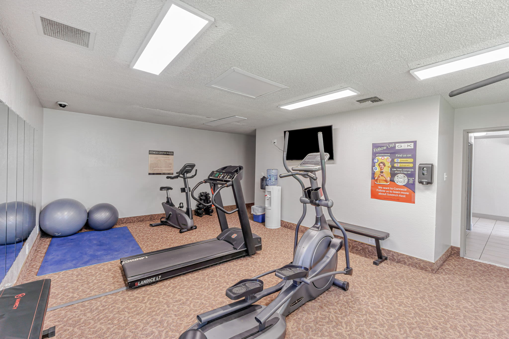 Gym with elliptical, treadmill, bikes, mats, and stability balls in a bright workout room at Clayton Gardens in Concord, California