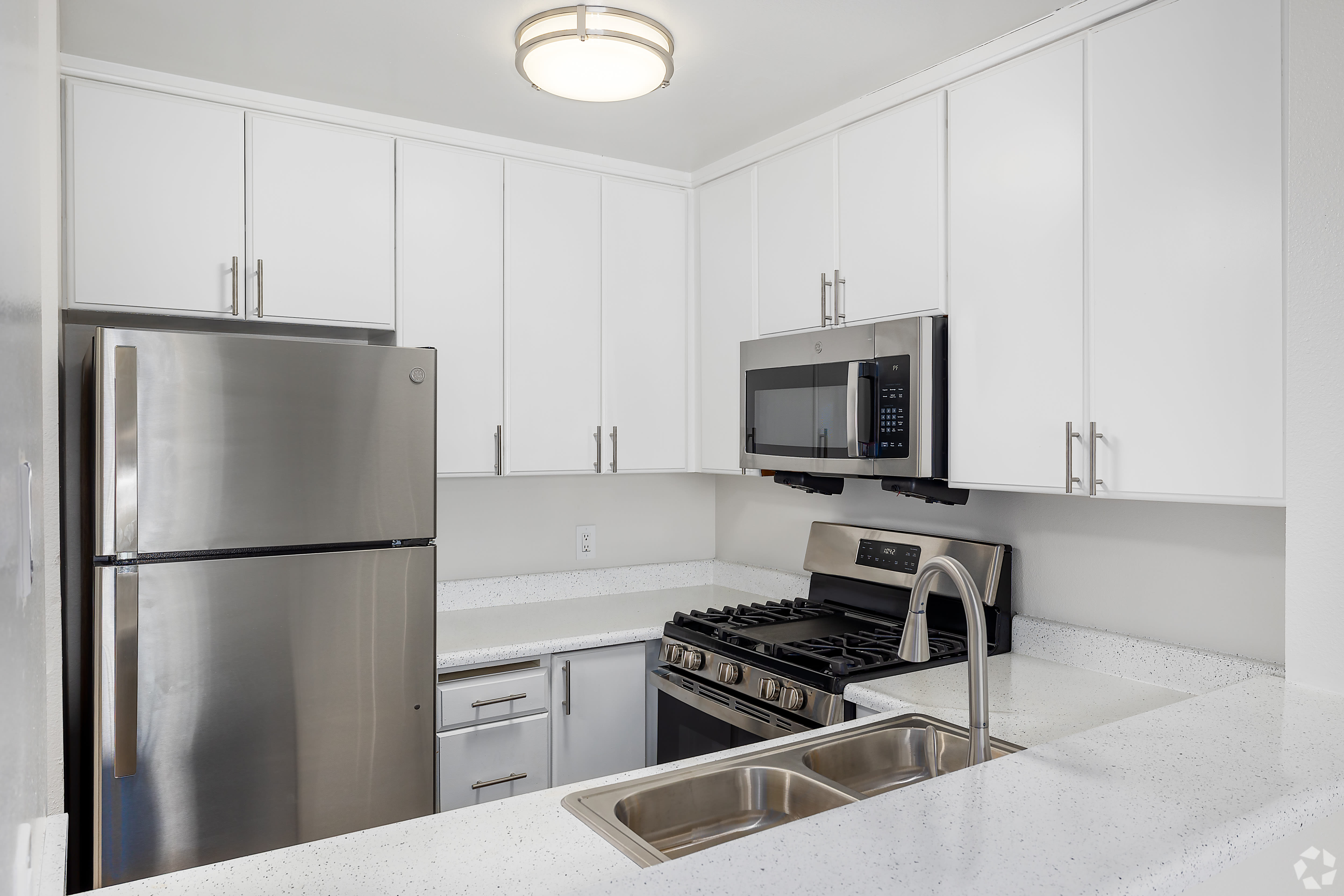 Modern kitchen with stainless appliances, white cabinets, and double sink at Beck Park in North Hollywood, California