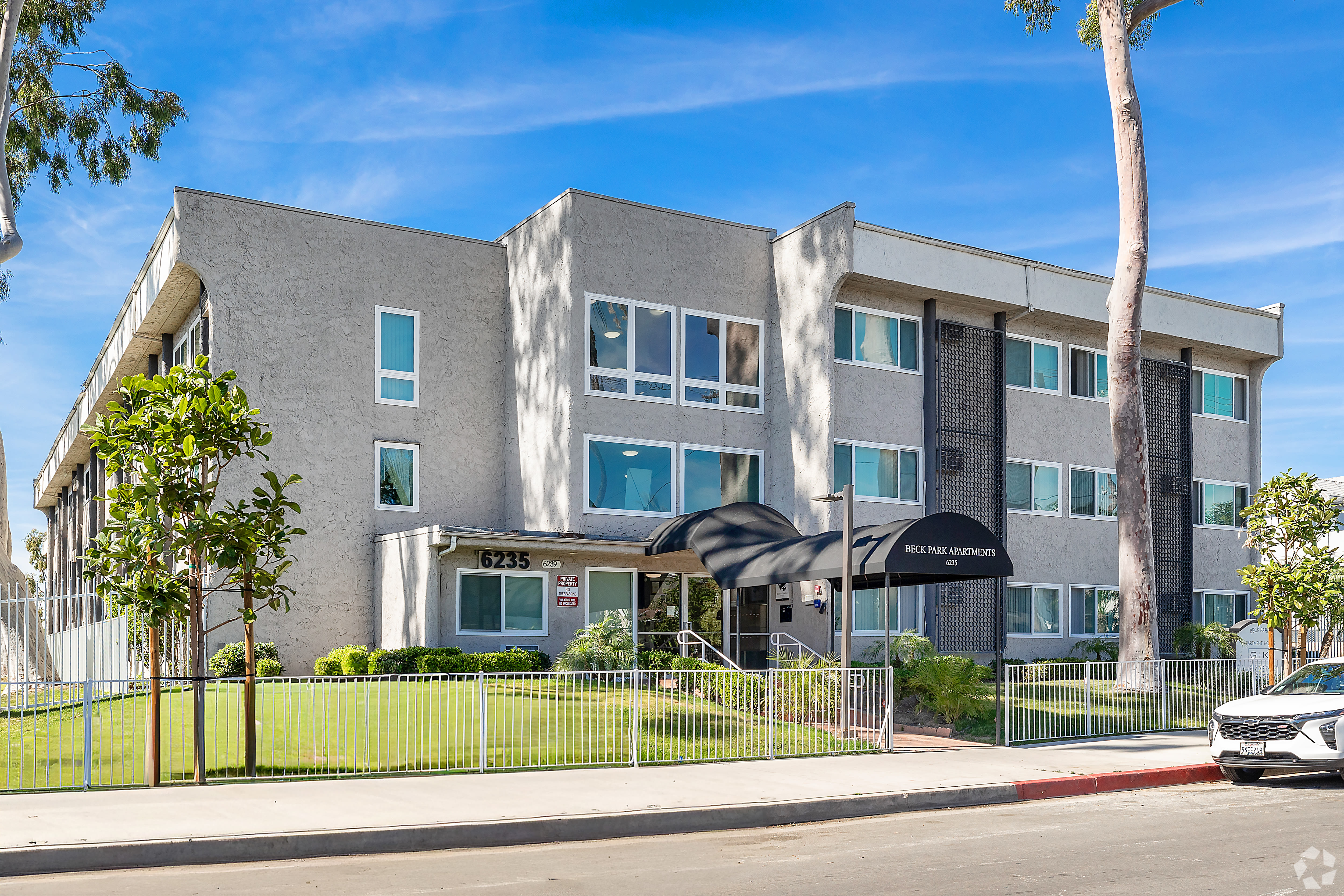 Three-story apartment building with gated lawn and modern exterior at Beck Park in North Hollywood, California