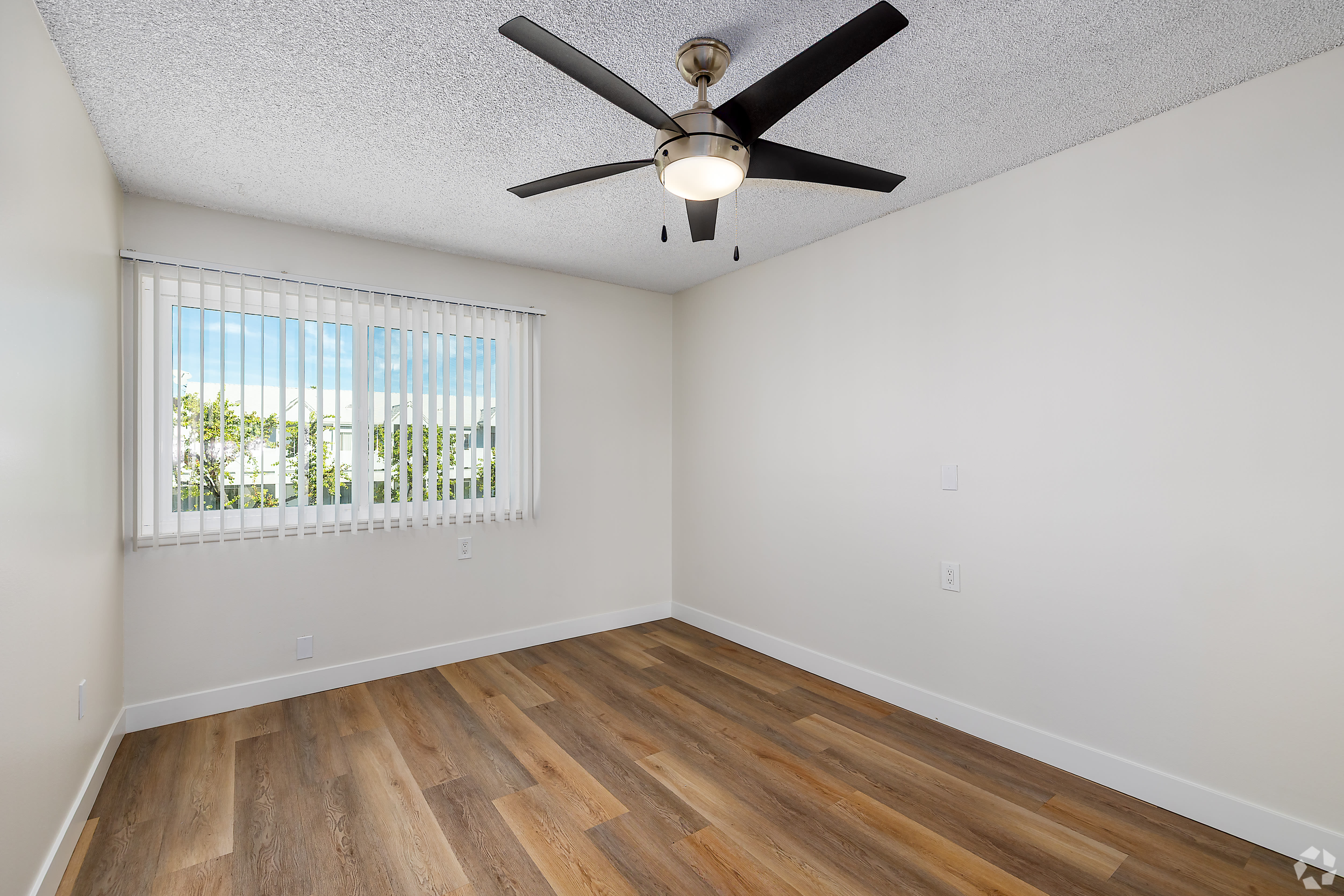 Bedroom with large window, wood floors, and ceiling fan at Beck Park in North Hollywood, California