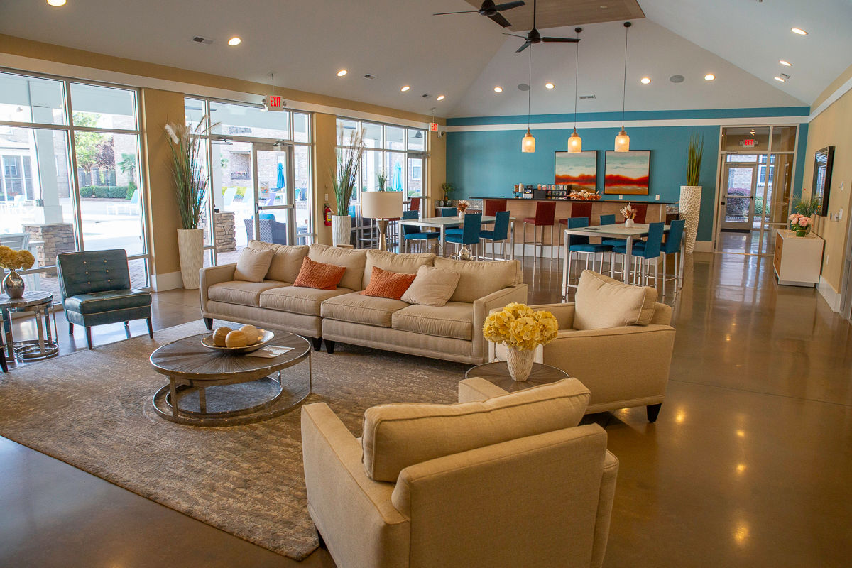 Large room with sofas, chairs, bar seating and wall of windows