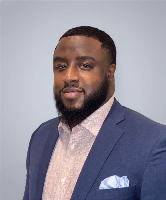 Team member headshot in blue suit, studio portrait at ATX Fenton in Austin, Texas