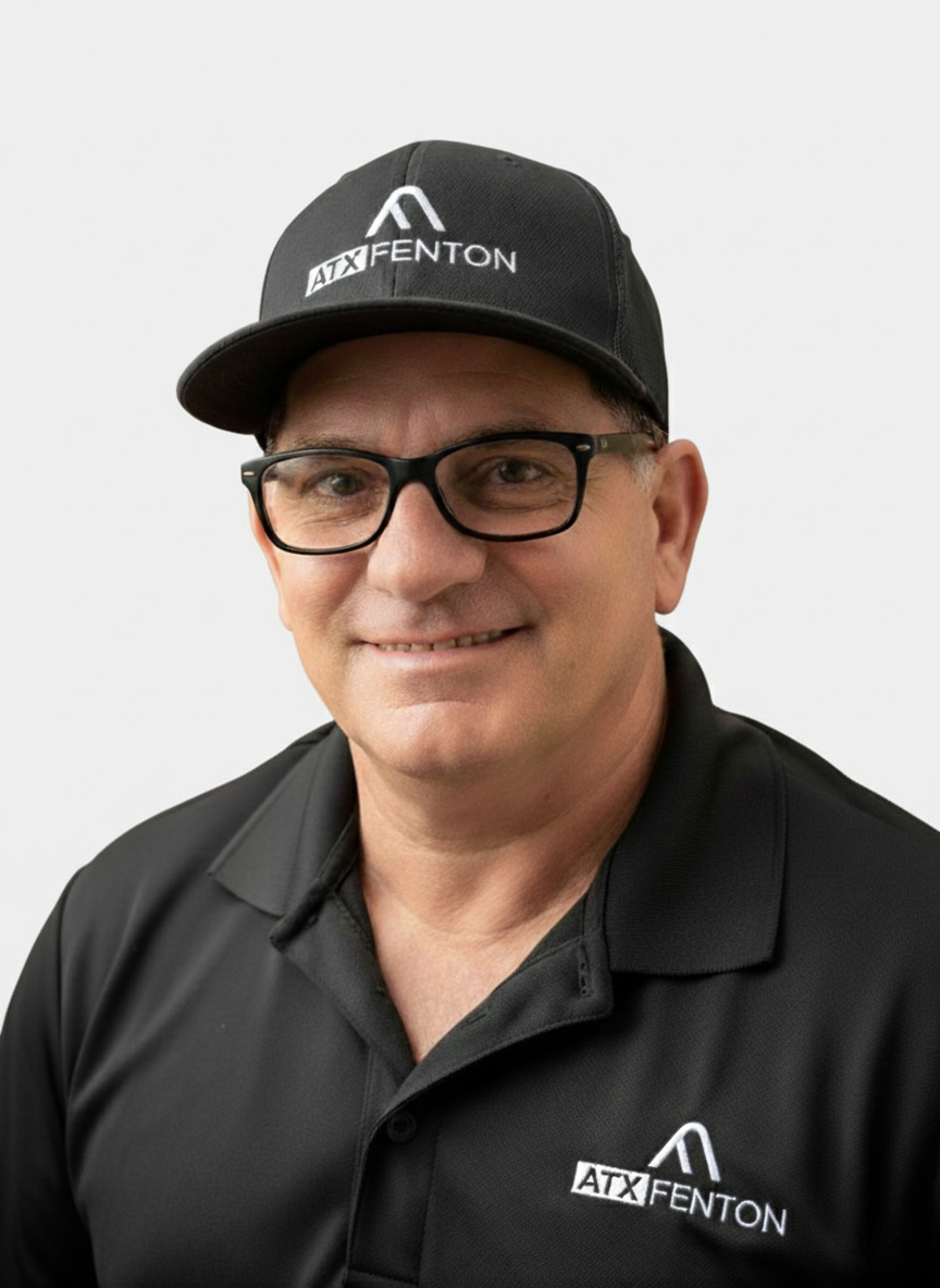ATX Fenton team member in branded cap and black polo, studio headshot at ATX Fenton in Austin, Texas