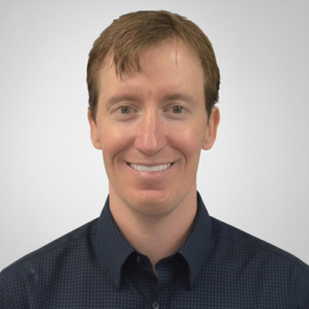 Professional team member headshot in blue button-down, studio portrait at ATX Fenton in Austin, Texas