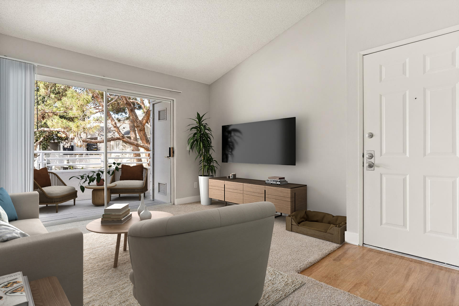 Bright living room with sofa, TV, and balcony view at Colony Parc in Ventura, California