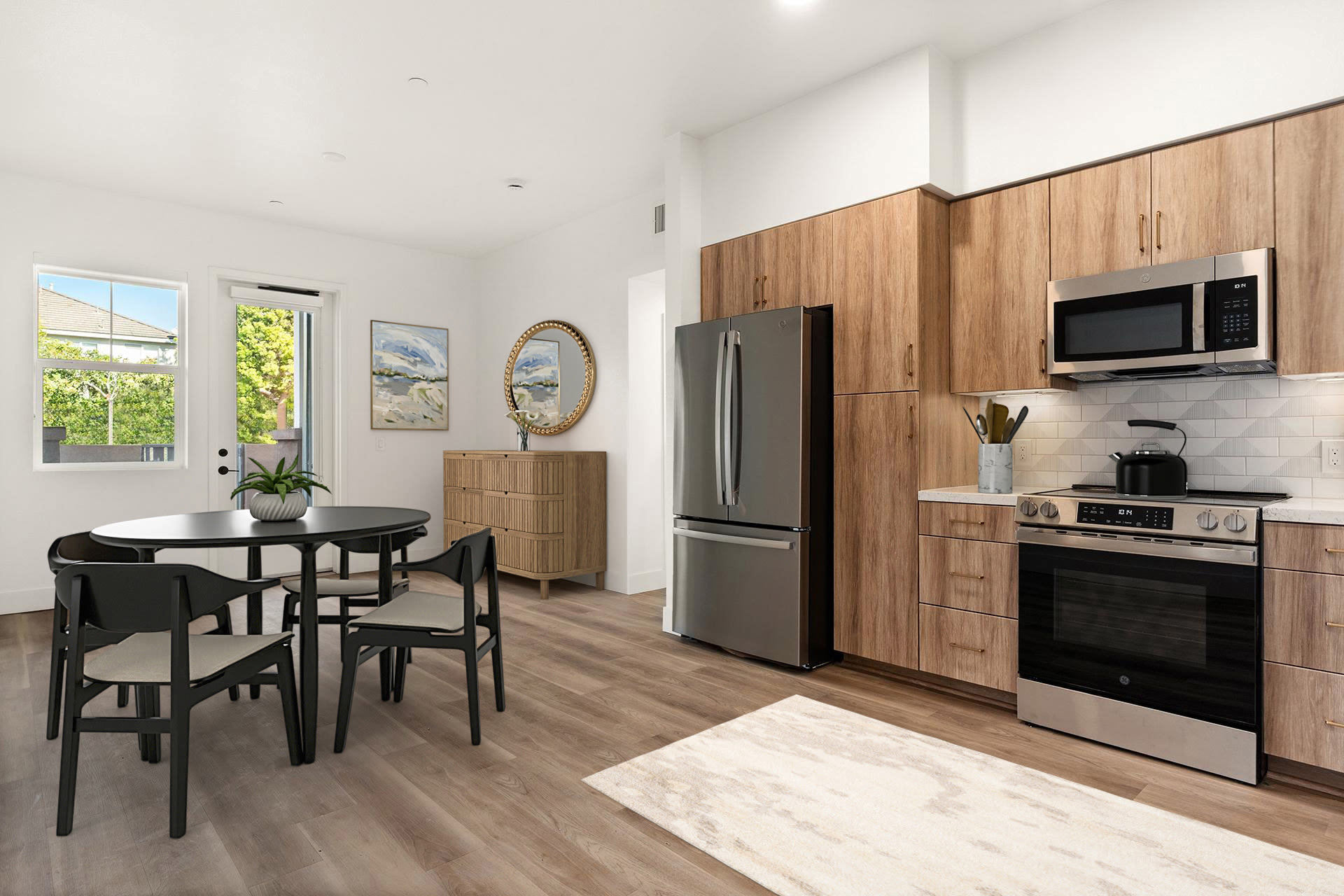 Open kitchen with wood cabinets, stainless appliances, and dining table at Colony Parc in Ventura, California