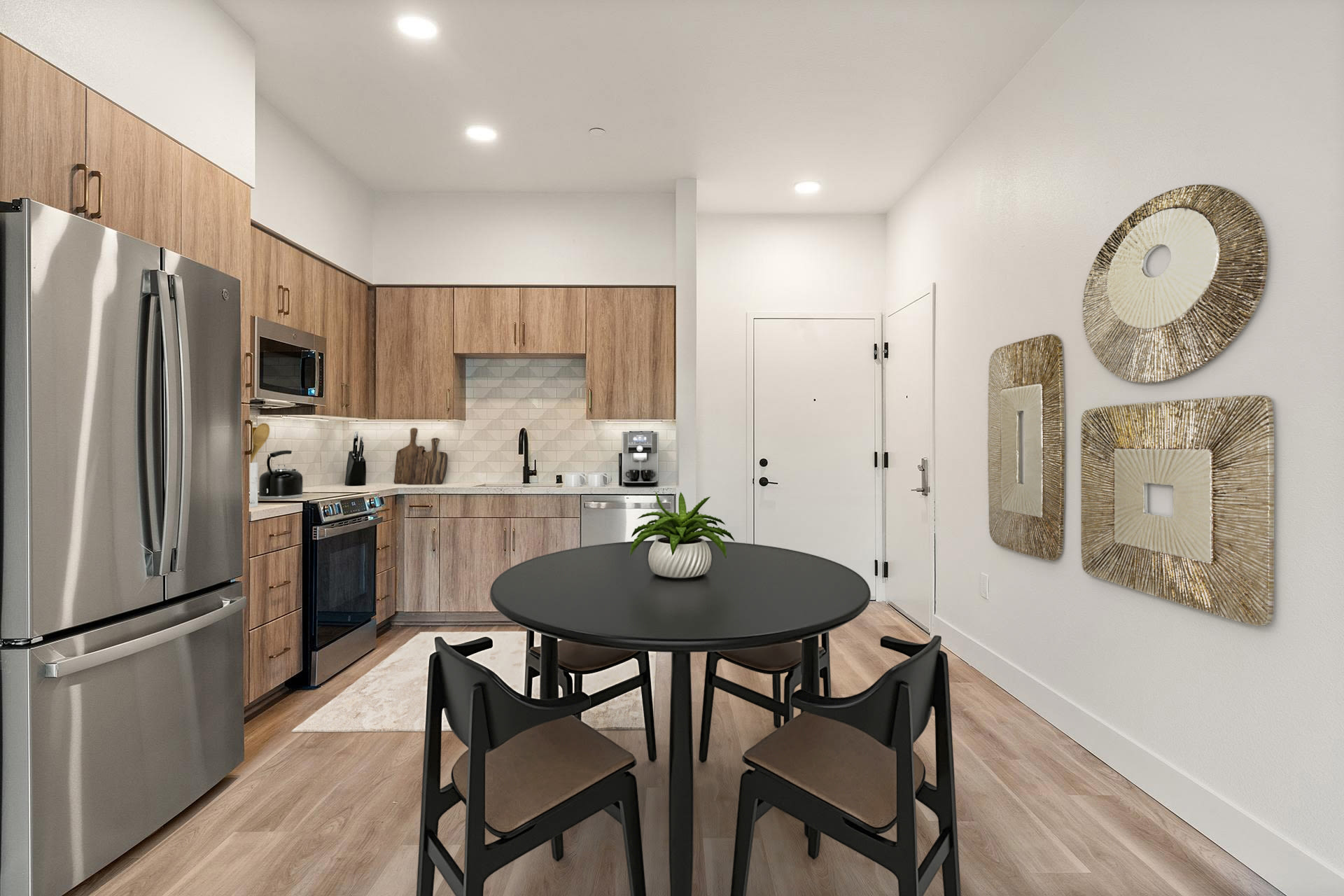 Modern kitchen and dining area with round table and stainless appliances at Colony Parc in Ventura, California