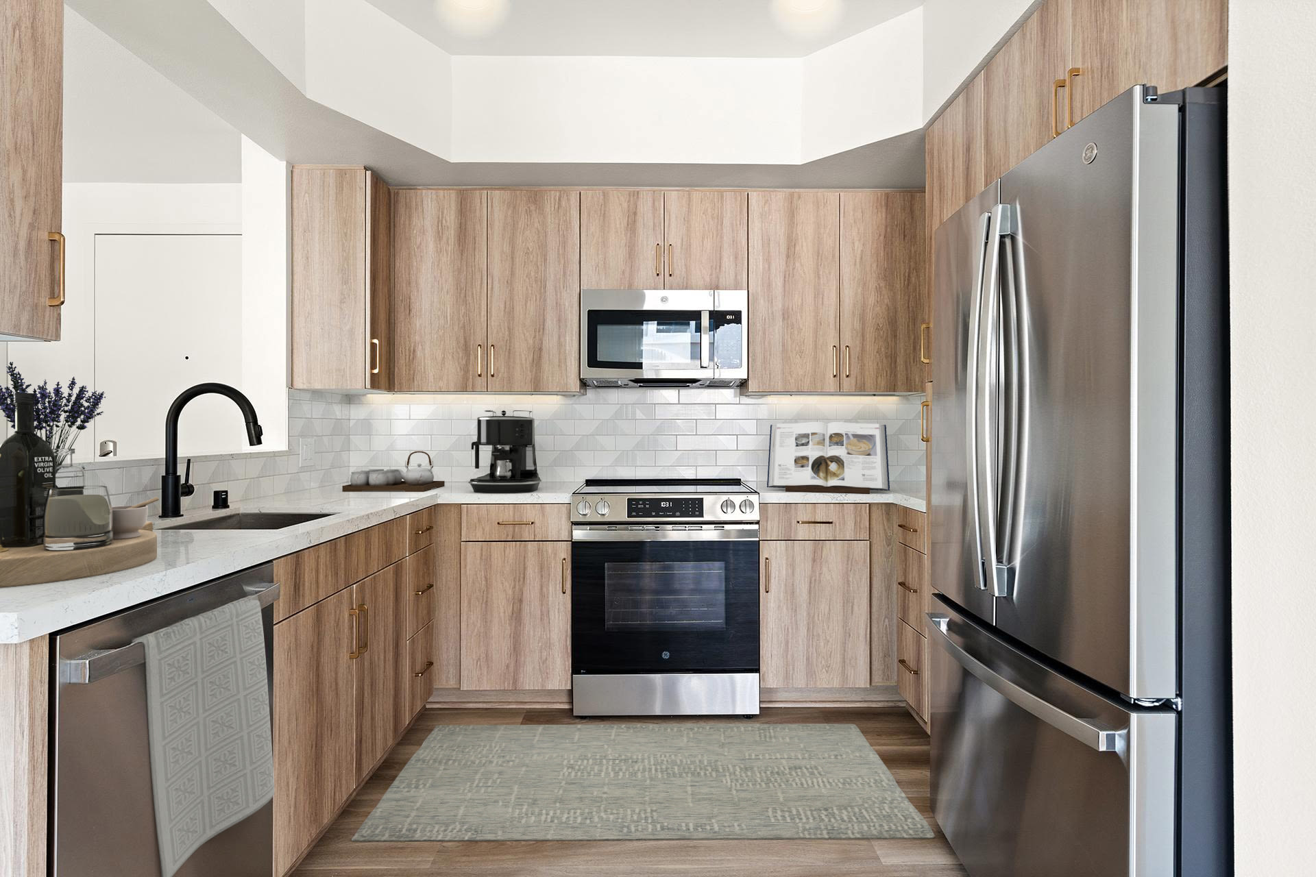 Contemporary kitchen with wood cabinetry, stainless stove, and refrigerator at Colony Parc in Ventura, California