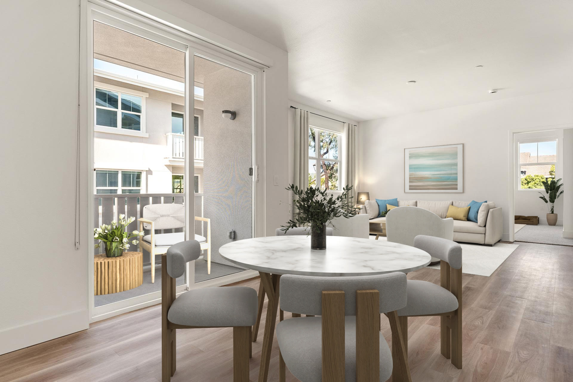 Dining area with round table, patio access, and adjacent living room at Colony Parc in Ventura, California
