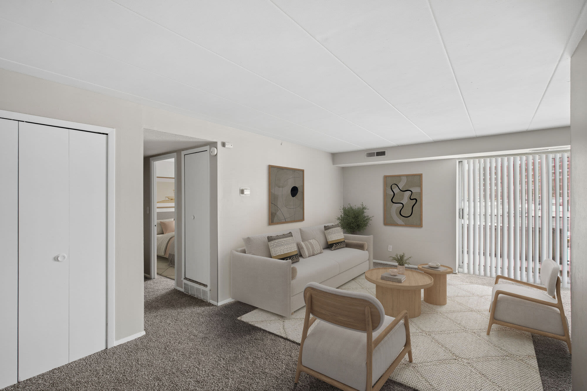 Spacious living area with comfortable seating, natural light, and sliding glass door at Granada Gardens Apartments in Warrensville Heights, Ohio 