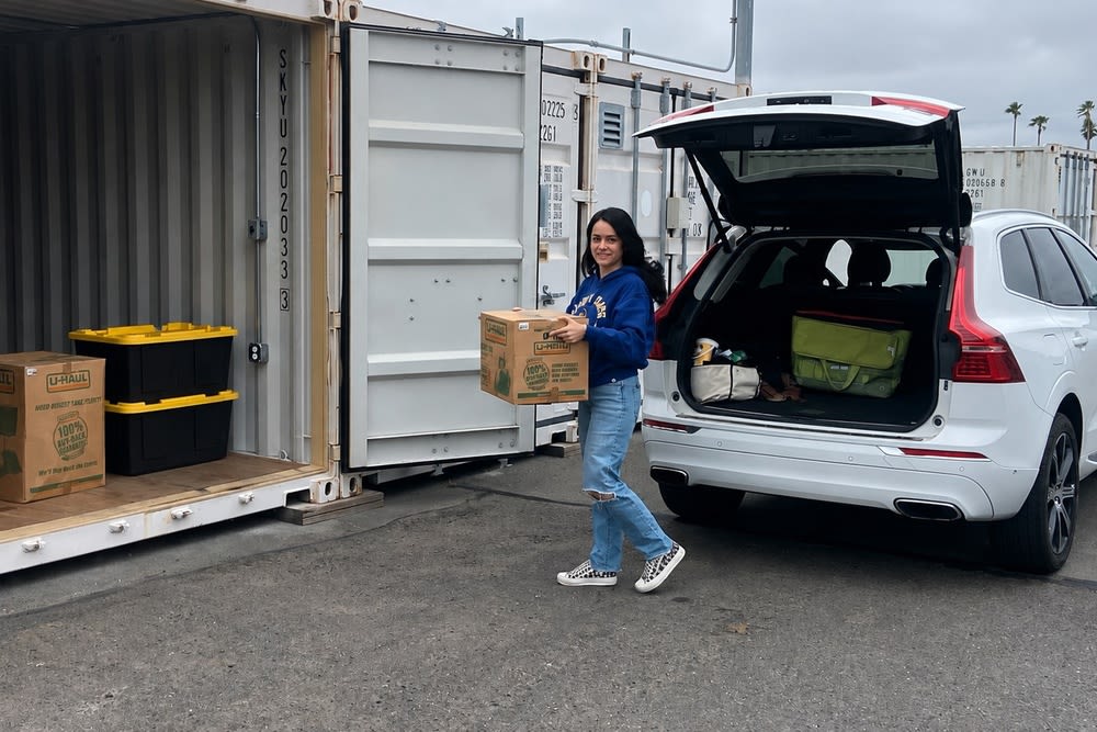 Customer unloading boxes from an SUV into a ground-floor drive-up storage unit at CSI Mini Storage Richmond