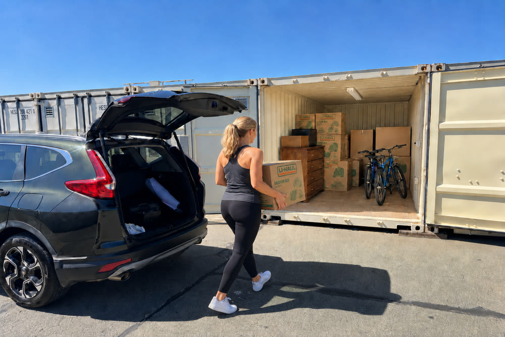 Woman carrying a box from an SUV directly into a ground-floor drive-up storage unit in Richmond, CA