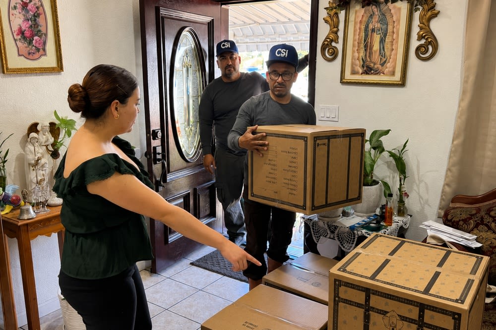 CSI Mini Storage Alameda move-in help team picking up boxes at a customer’s home while the customer points to items for pickup.