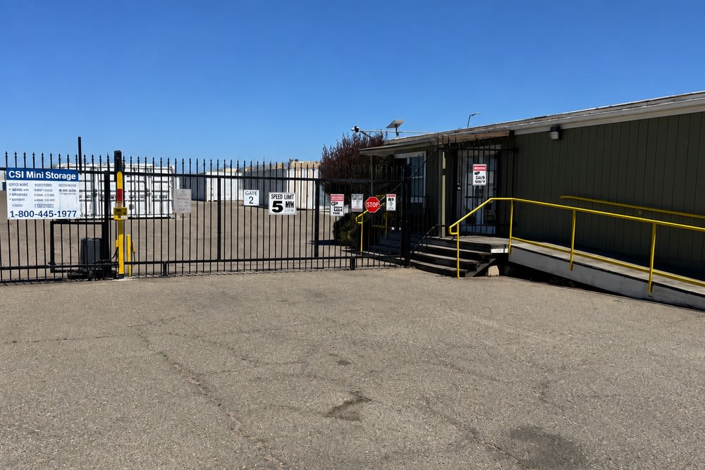 Gated entrance, access ramp, office, and storage buildings at CSI Mini Storage Alameda.