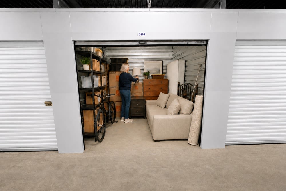 10x10 storage unit in Tacoma, WA with sofa, mattress, dresser, shelving, bicycle, boxes and household furniture