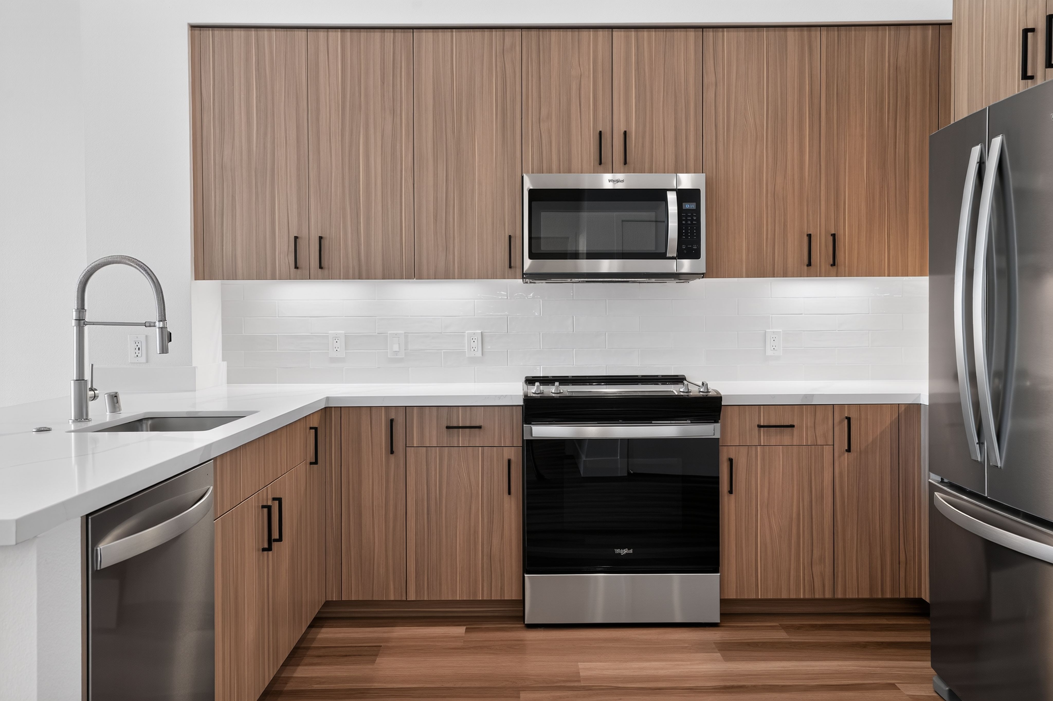 Modern kitchen with stainless steel appliances and white cupboards at The Colton in Redwood City, California