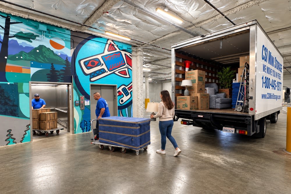 CSI Mini Storage Tacoma movers transferring protected furniture from the move-in truck to the elevator