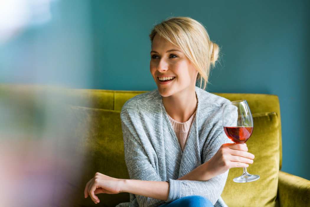 A resident relaxes with a glass of wine in her vibrantly colored apartment at The Ellison, Las Vegas, Nevada