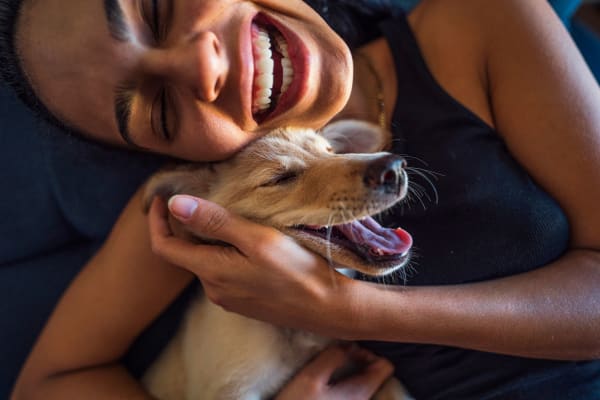 Happy resident and her pup at Paseo Plaza Apartments in Brownsville, Texas