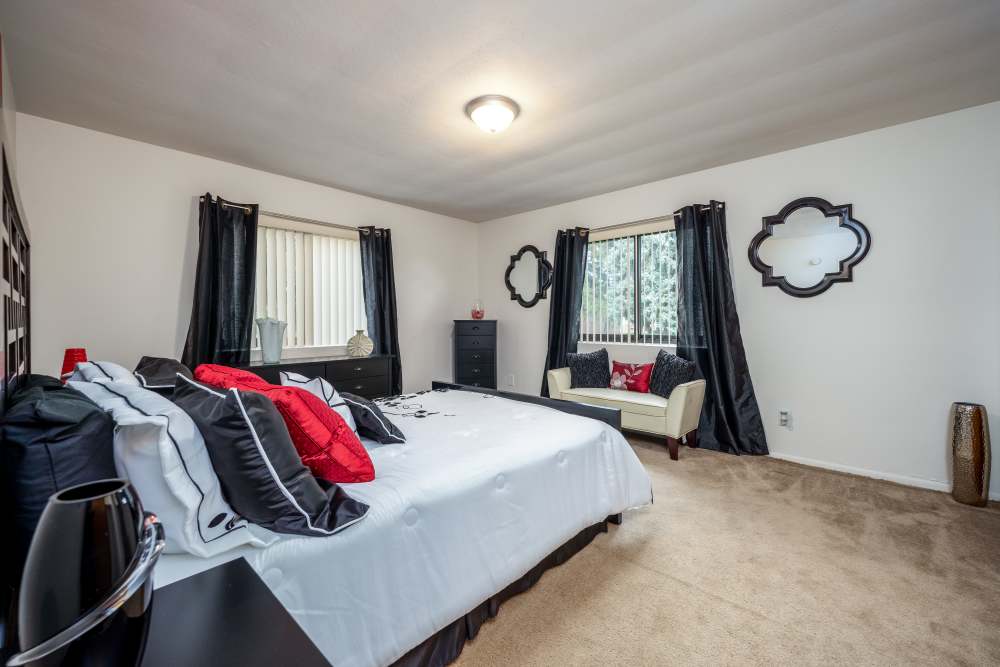 Bedroom with a bed and a large window at Greece Commons Apartments in Rochester, New York