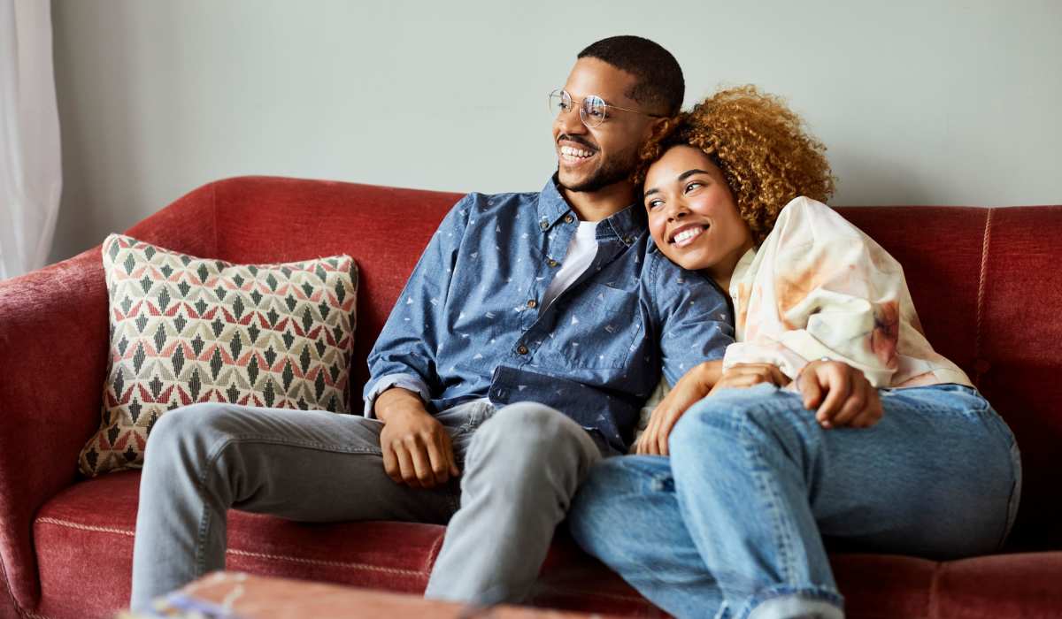 A couple laughing and embracing on their couch at Mirada Apartments in Lewis Center, Ohio