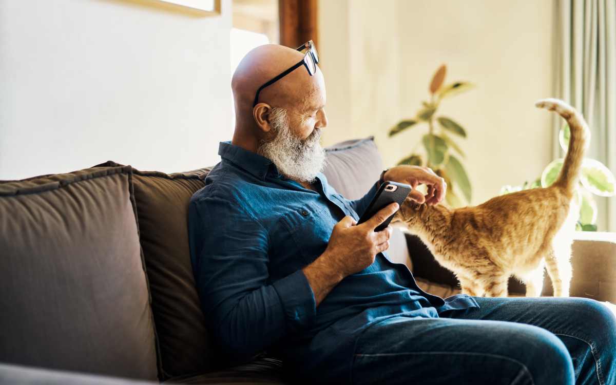 Resident petting his cat in their pet-friendly home at Highland Manor Apartments in Rochester, New York