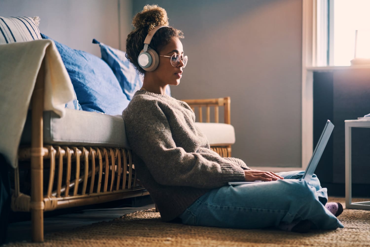 Resident listening to music with headphones connected to her laptop in her apartment at Park Place Apartments in Del Mar, California