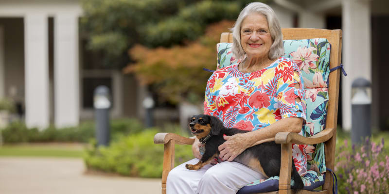 Resident with her dog enjoying the outdoors at Glenncrest at Decatur in Decatur, Georgia