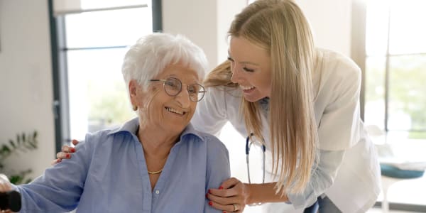 Resident and nurse laughing together at Retirement Ranch in Clovis, New Mexico