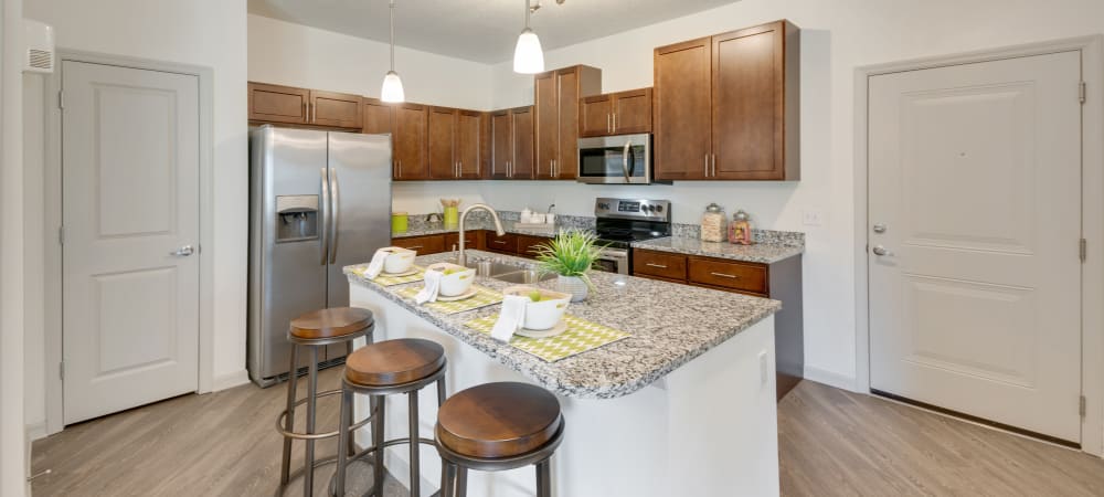 Kitchen area with island and bar seating at Champions Vue Apartments in Davenport, Florida