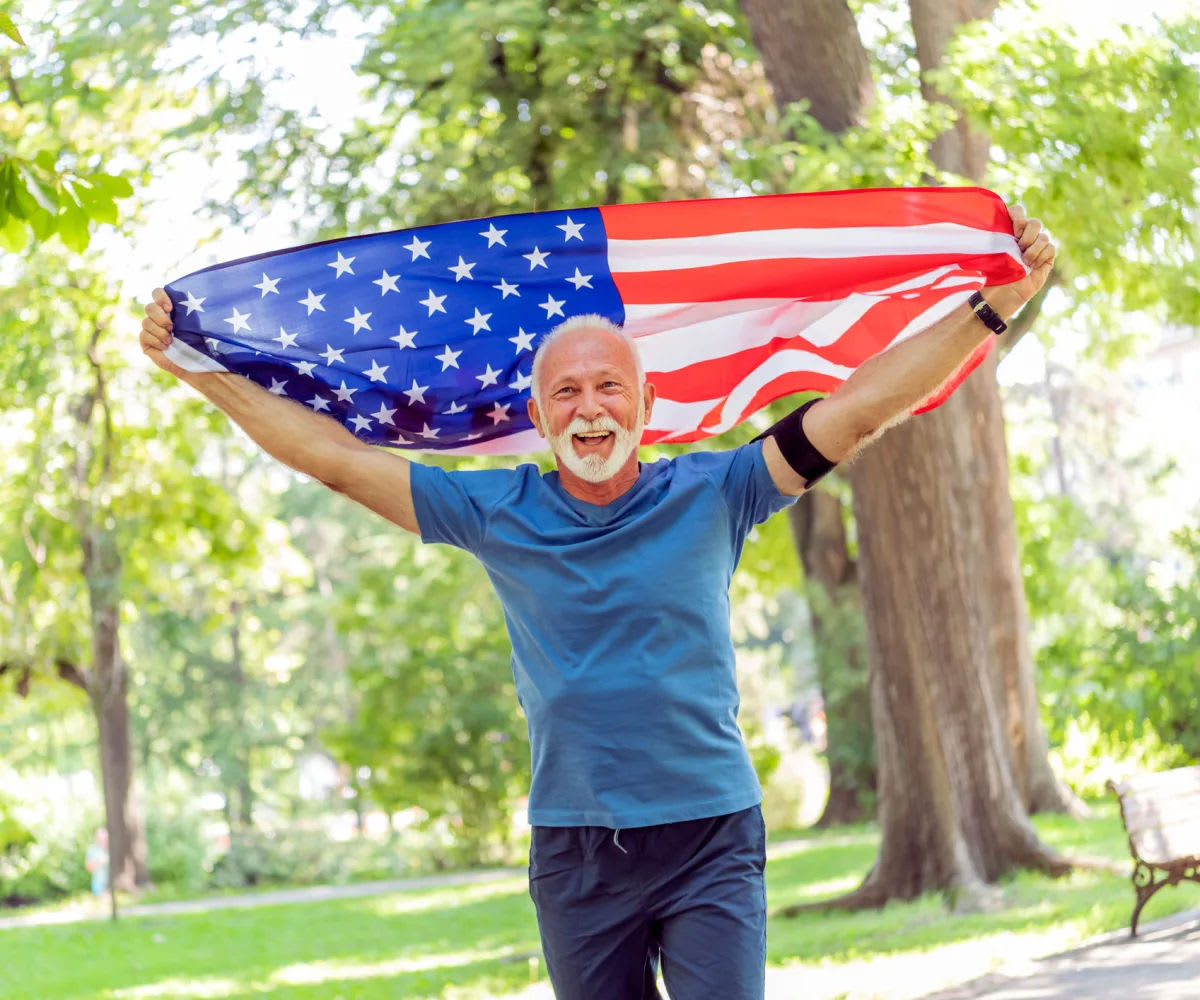 Resident holding an american flag at Carriage Inn Huntsville in Huntsville, Texas