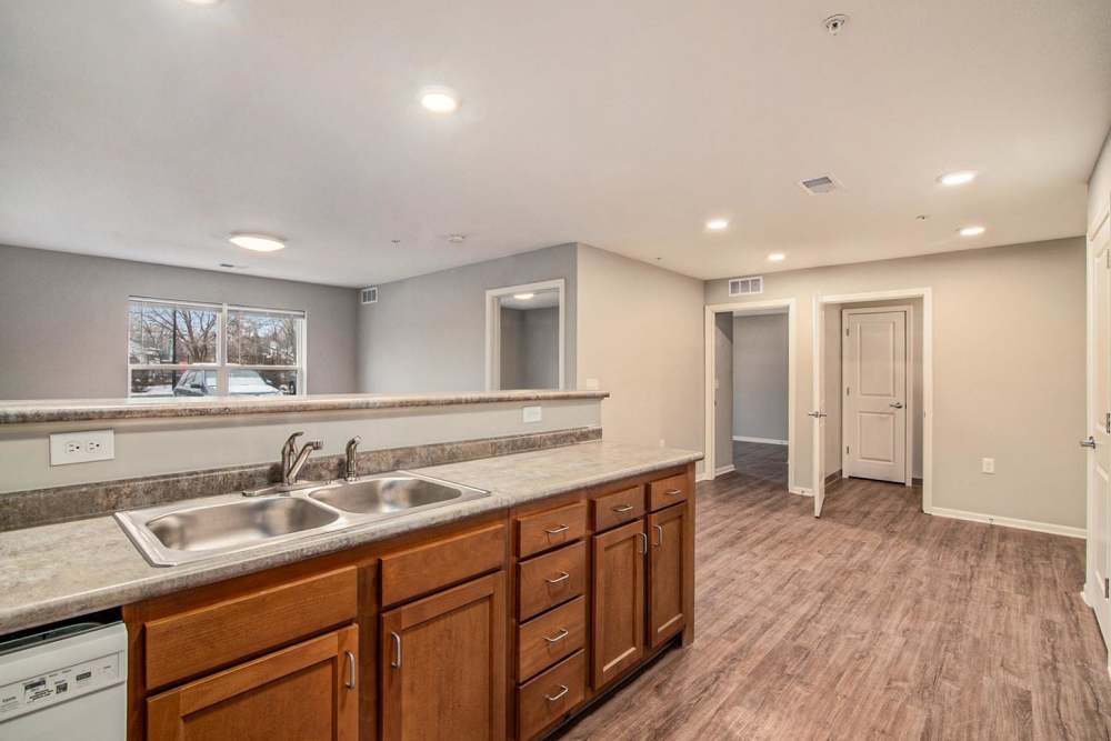 Open layout kitchen with granite countertops, wood-style flooring, and stainless steel appliances at Ruth Park in Traverse City, Michigan