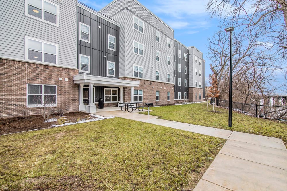 Modern apartment building with outdoor picnic area and landscaped green space at Ruth Park in Traverse City, Michigan