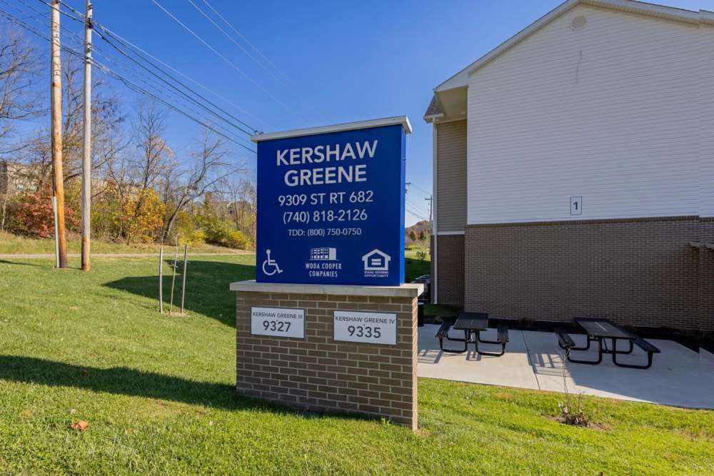 Community sign with grassy area and picnic tables nearby at Kershaw Greene III in Athens, Ohio