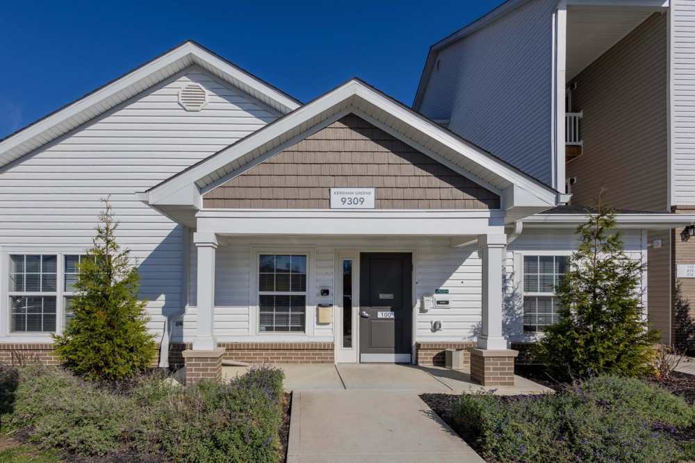 Modern apartment entrance with landscaped shrubs and a welcoming porch area at Kershaw Greene III in Athens, Ohio