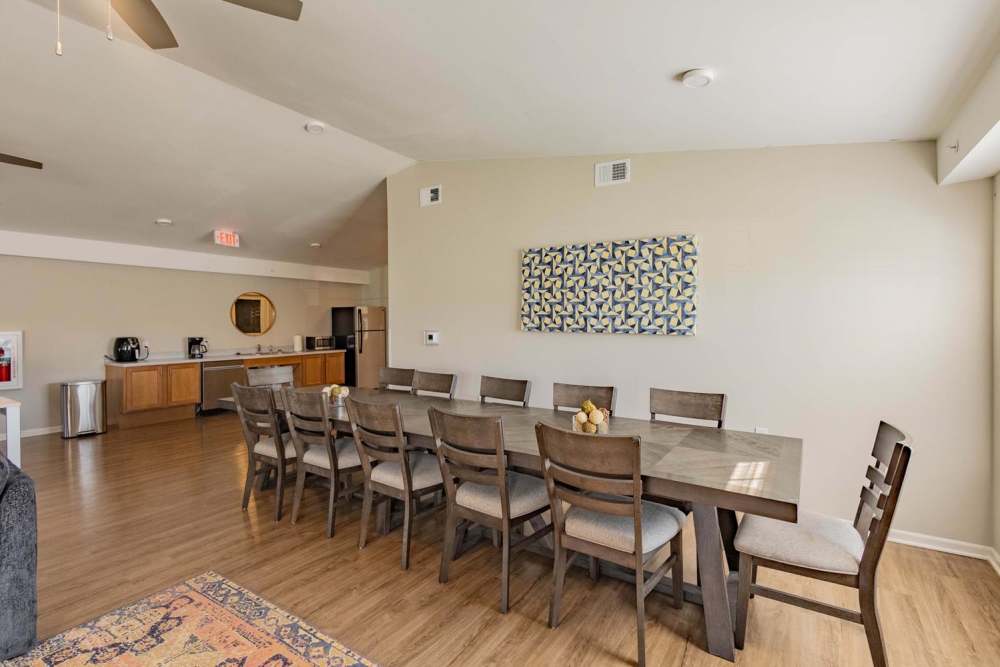 Spacious dining area with wooden table and modern kitchen appliances in open layout at Kershaw Greene III in Athens, Ohio
