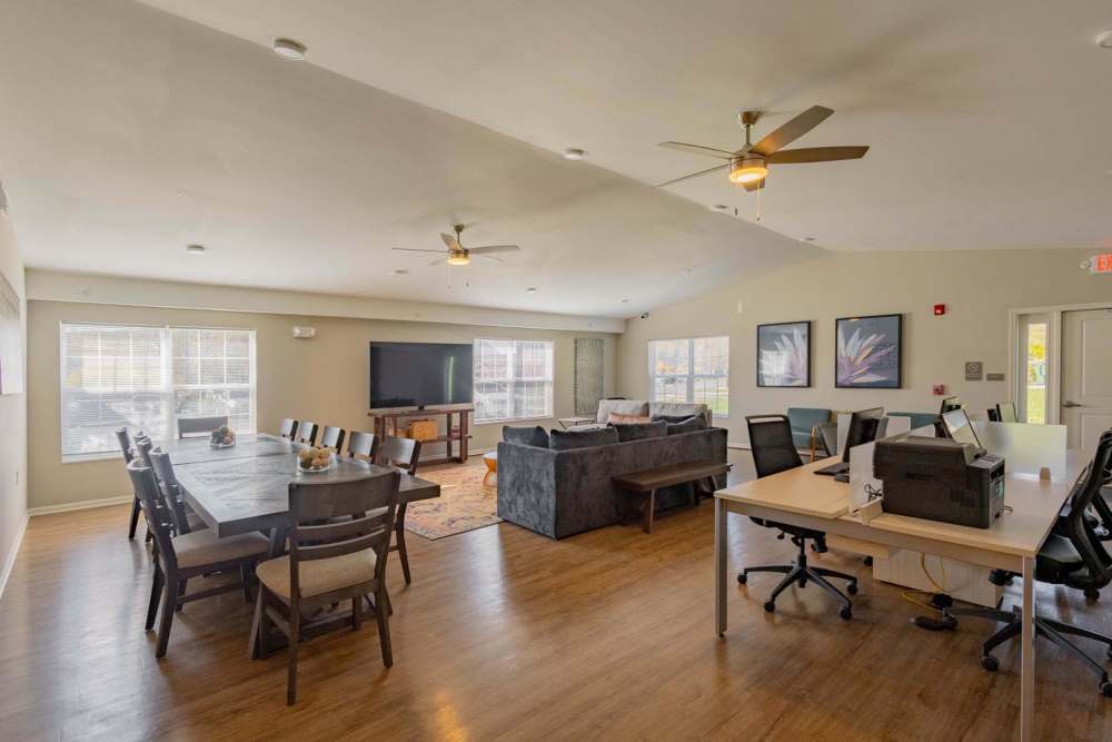 Spacious community lounge with wood-style flooring, dining table, and comfortable seating area at Kershaw Greene III in Athens, Ohio