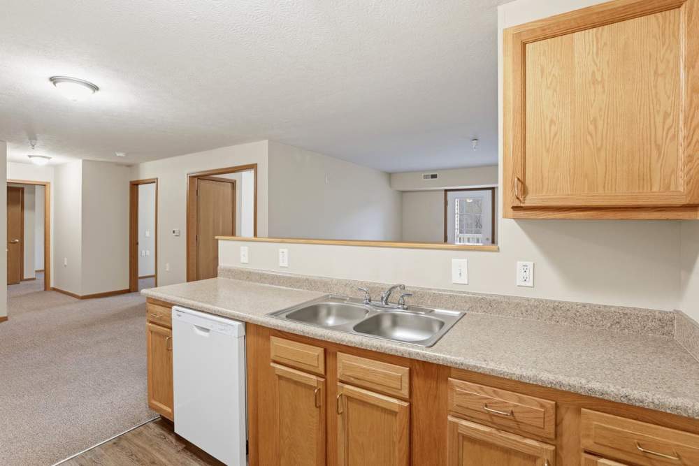 Bright kitchen featuring granite countertops, stainless steel appliances, and wood-style flooring in open layout at Norwood Greene Senior Living in Marietta, Ohio