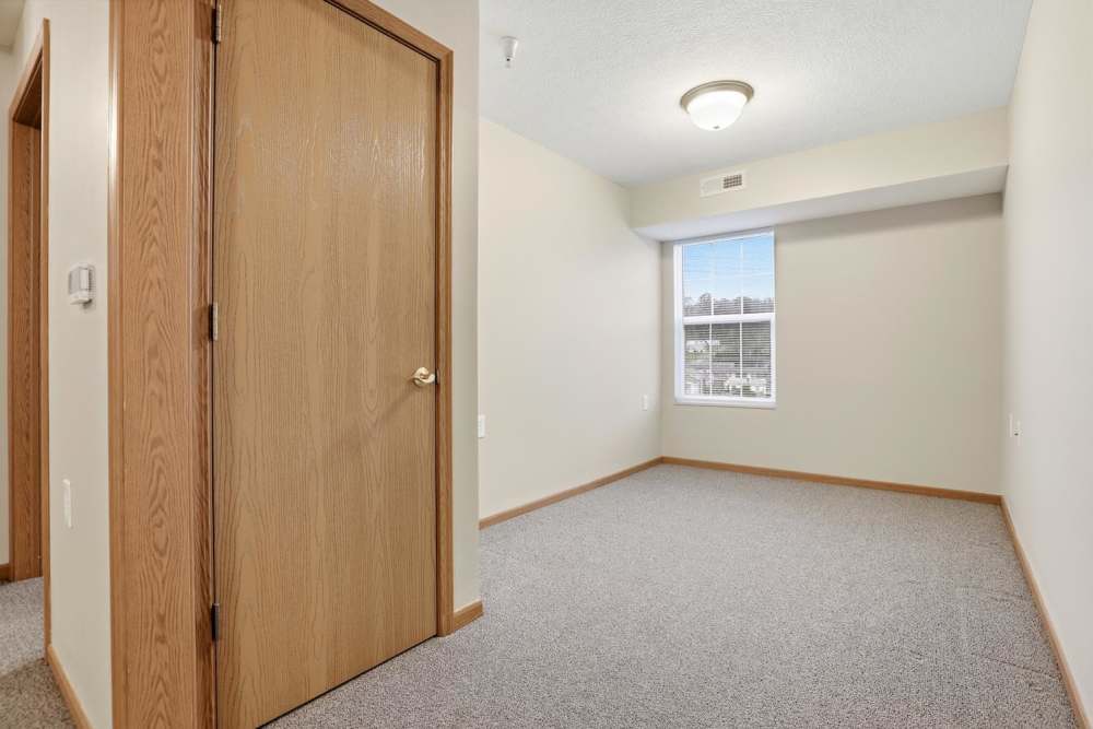 Spacious room with carpeted flooring, window for natural light, and neutral wall colors at Norwood Greene Senior Living in Marietta, Ohio