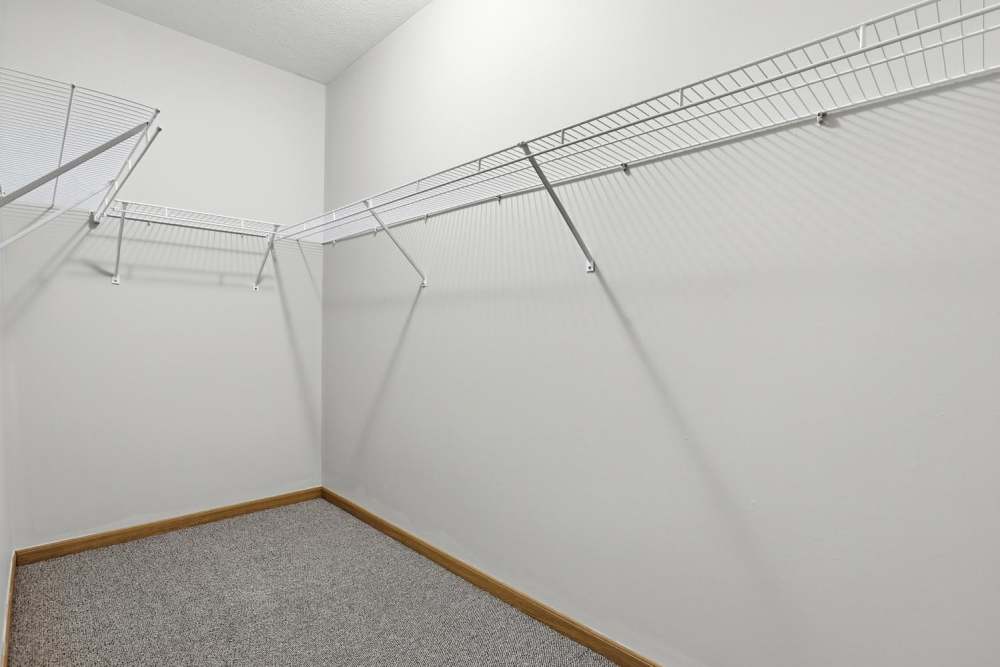 Spacious walk-in closet with wire shelving and carpeted flooring at Norwood Greene Senior Living in Marietta, Ohio