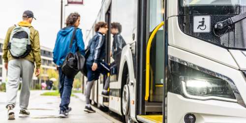 People getting on a bus near Mountain Breeze Villas in San Bernardino, California