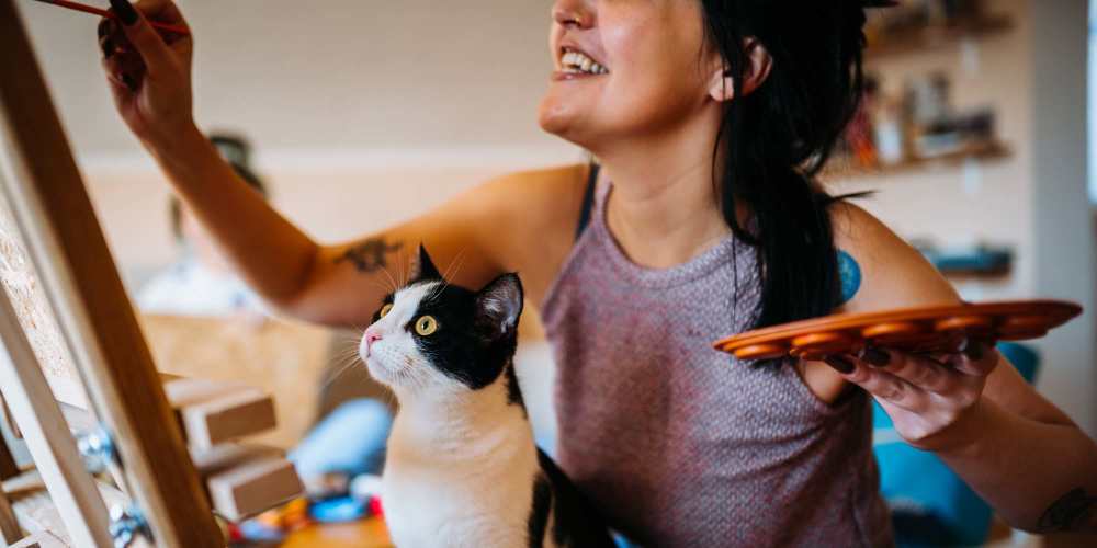 Resident painting with her cat at The Oliver in Charlotte, North Carolina